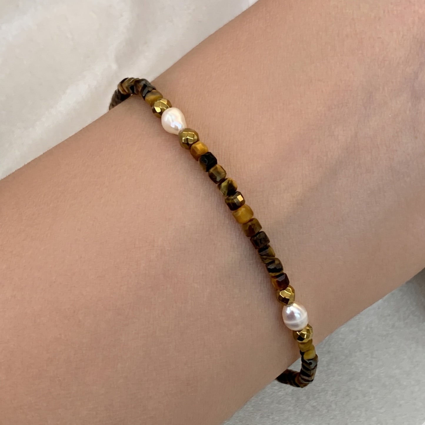 Pulseira em Nylon, com olhos-de-tigre, pérolas barrocas e hematitas douradas